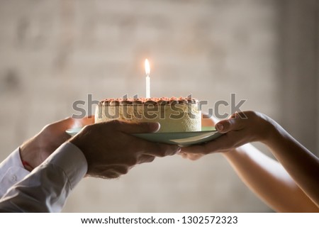 Close up of worker congratulate colleague with birthday, presenting baked cake with lit candle, employee greeting coworker, giving holding cream pie, celebrating, throwing party in office