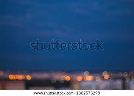 The lights of the night city. Blurred background. Abstract unfocused picture. Lanterns on the street. Evening shedding grisont.