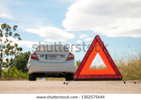 Emergency stop sign and broken car on road. 