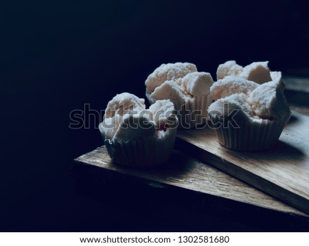 Thai steamed cupcakes or Thai Rice Flour Muffin, dessert,on empty old wood planks,with space for your text design.Rustic still life and dark background,dimly light.