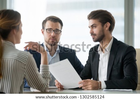Skeptical male hr managers unconvinced about hiring female candidate, doubtful company recruiters feel uncertain listen to applicant at job interview, bad impression, gender discrimination concept Royalty-Free Stock Photo #1302585124