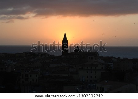 Sunset of the Alghero Cathedral  bell tower (Santa Maria) and of the historic centre. Sardinia, Italy. 
