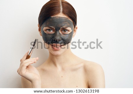woman puts a cosmetic mask on her face