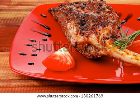 meat over white : grilled meat shoulder on red plate with tomatoes green lettuce over wooden table