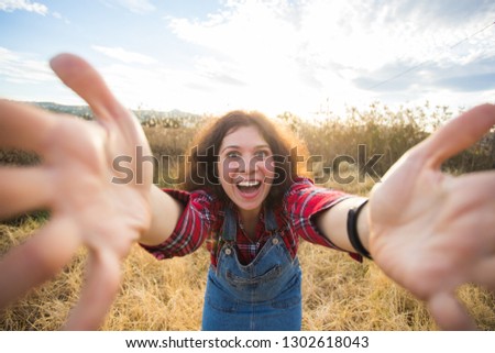 Travel, vacation and holiday concept - Happy young woman having fun taking selfie against background on the field