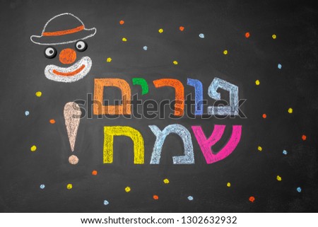 Colorful bright inscription in chalk on hebrew Happy Purim school board. Painted clown on a chalk board.