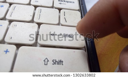 Index finger presses the Enter key on the computer keyboard