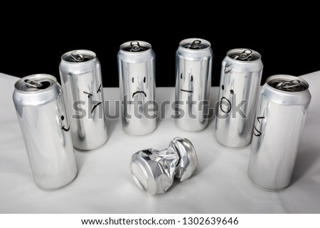 One little beaten surrounded by big. Concept of empty people with different emotions. Aluminium cans with drawned emoji on black background