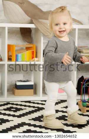 Portrait of a cute baby standing in a playroom