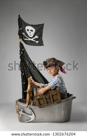 Little boy imagine themselve as pirate searching for treasure on the ship