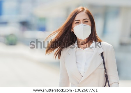 Asian woman are going to work.She is wearing a mask N95. To prevent dust, pm 2.5 Royalty-Free Stock Photo #1302689761