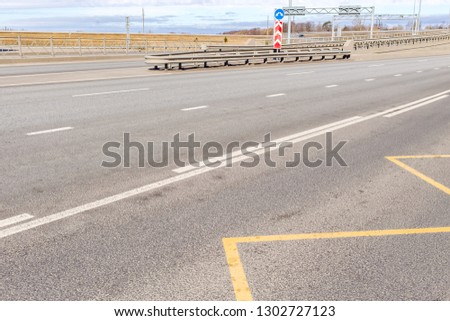 Different types of asphalt concrete roads, with markings and cars and trucks, with dividing lanes and signs, large and small bridges, traffic lights, curbs