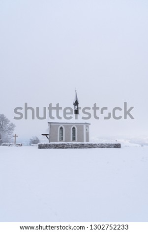 Winter Switzerland Landscape of small chapel on hill with fresh snow looking as if in a fairytale (Cinderella)