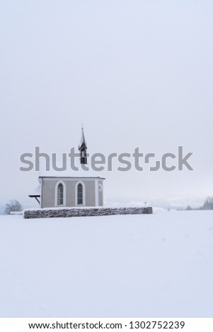 Winter Switzerland Landscape of small chapel on hill with fresh snow looking as if in a fairytale (Cinderella)