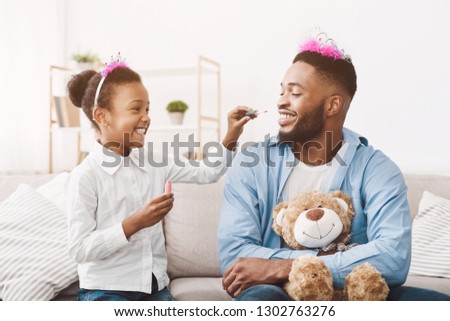 Funny time. Daughter doing makeup to her dad, playing at home