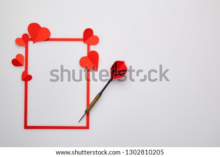 Valentine's day background with love gift, red darts and paper heart shapes. View from above. Copy space. Flat lay.