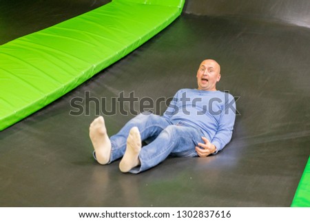 The man on a trampoline. The man fell on a trampoline. Man first time on trampoline.