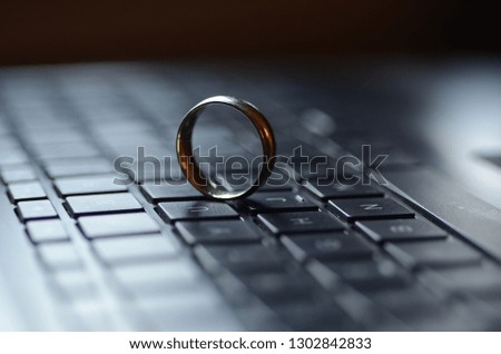 A gold ring appears on the keyboard of a laptop computer.