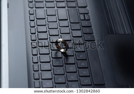 A gold ring appears on the keyboard of a laptop computer.