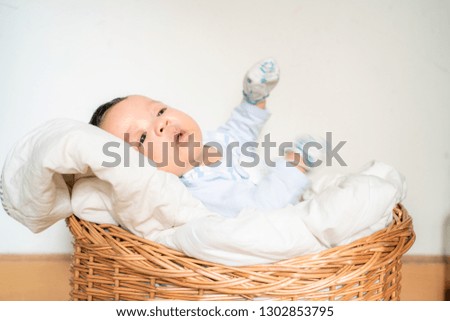 Infant baby lying on blanket in wood baket on white background copyspace