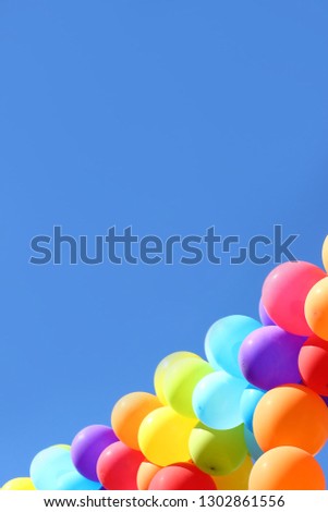 Festive multi-colored balloons in the blue sky