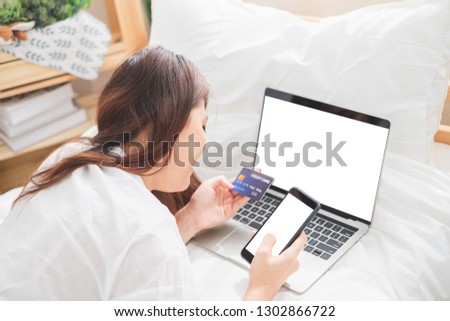 Beautiful Asian woman using laptop and smart phone in bed room for online shopping, Asian woman lifestyle concept