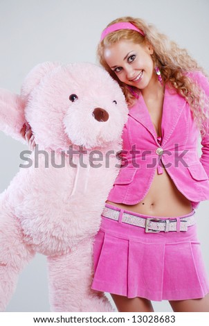 The girl dressed in pink with a teddy-bear in hands