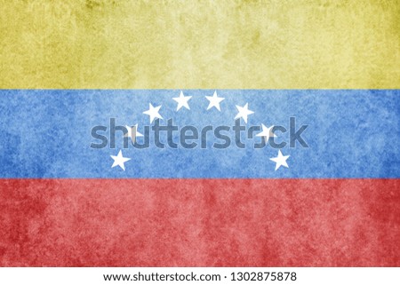 Venezuela flag on concrete wall. Grunge wallpaper.
