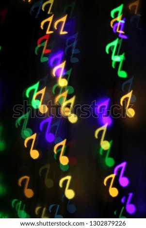 colorful bokeh on a dark background in the form of musical notes