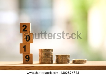 Happy new year 2019 with stack of coins on wooden table with copy space. Business, financial, and investment concept 