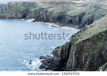 top view, floor, rocky coastline with different projections, caves, waterfall; rocky shore where only the grass grows