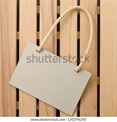 Paper signboard with rope on a wooden background