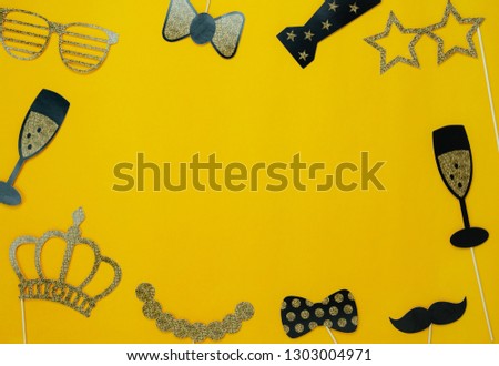Flat lay aerial image of sign of carnival festival background concept. DIY photo booth props for decorations on modern rustic yellow paper at home office desk studio.Space for creative background.