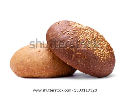 Brown and yellow freshly baked round sesame bun isolated on white background. Flour and bakery products 