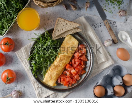 Perfect eggs omelette with vegetable salad, fresh arugula and juice