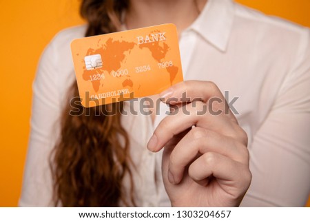 Picture of a girl holding orange credit card