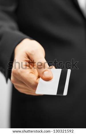 picture of man in suit holding credit card.