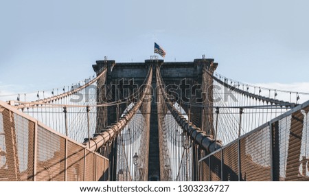 A symmetrical shot of the iconic Brooklyn Bridge, showcasing its complex structure and interlacing lines.