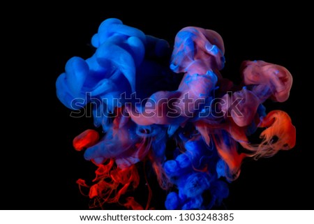 Color splashes of paint isolated on black background. Abstract paint in water