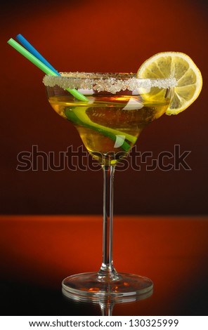 Yellow cocktail in glass on color background