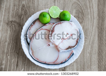 raw blue shark meat and lime on white plate