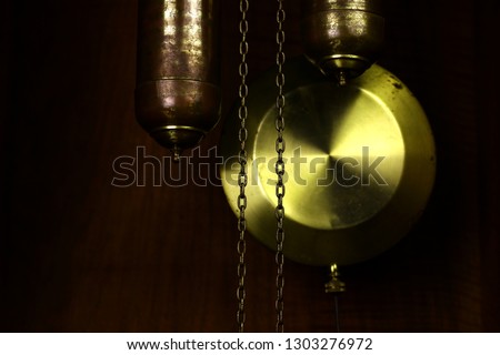 The pendulum of old antique floor clocks and chains with weights. 