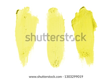 Smear and texture of lipstick or acrylic paint isolated on white background. Stroke of lipgloss or liquid nail polish swatch smudge sample. Element for beauty cosmetic design. Yellow color