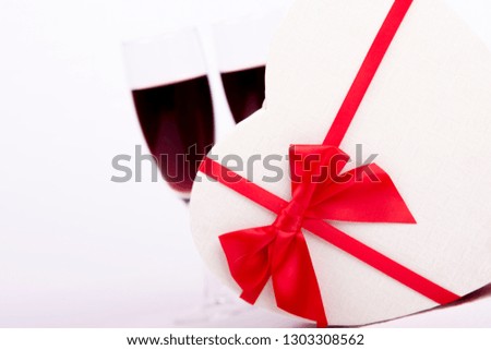 Wine and present  gift boxes on white background,Valentines day background.
Valentines Day gift in red box with two glass of wine