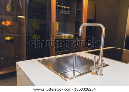 Stainless steel crane and marble countertop. Kitchen interior