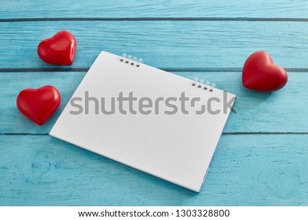 Heart and a empty calendar on bright blue wooden board for valentines day and love concept with copy space for text