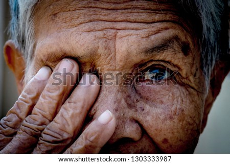 Old women cover her eye with her hand for eye testing use for medical and healthcare background Royalty-Free Stock Photo #1303333987
