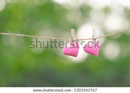 couple pink heart shape decoration hanging on line with copy space for text on green nature background. Love, Wedding Romantic and Happy Valentine’ s day holiday concept