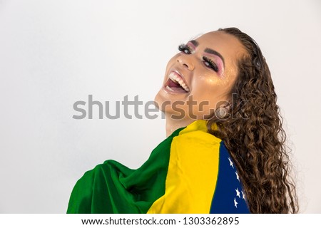 Brazilian woman fan holding the flag of Brazil on white background.Young smiling Brazilian woman smiling to camera with the flag