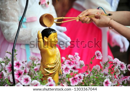 Pouring water onto a Buddha statue on the Buddha's birthday